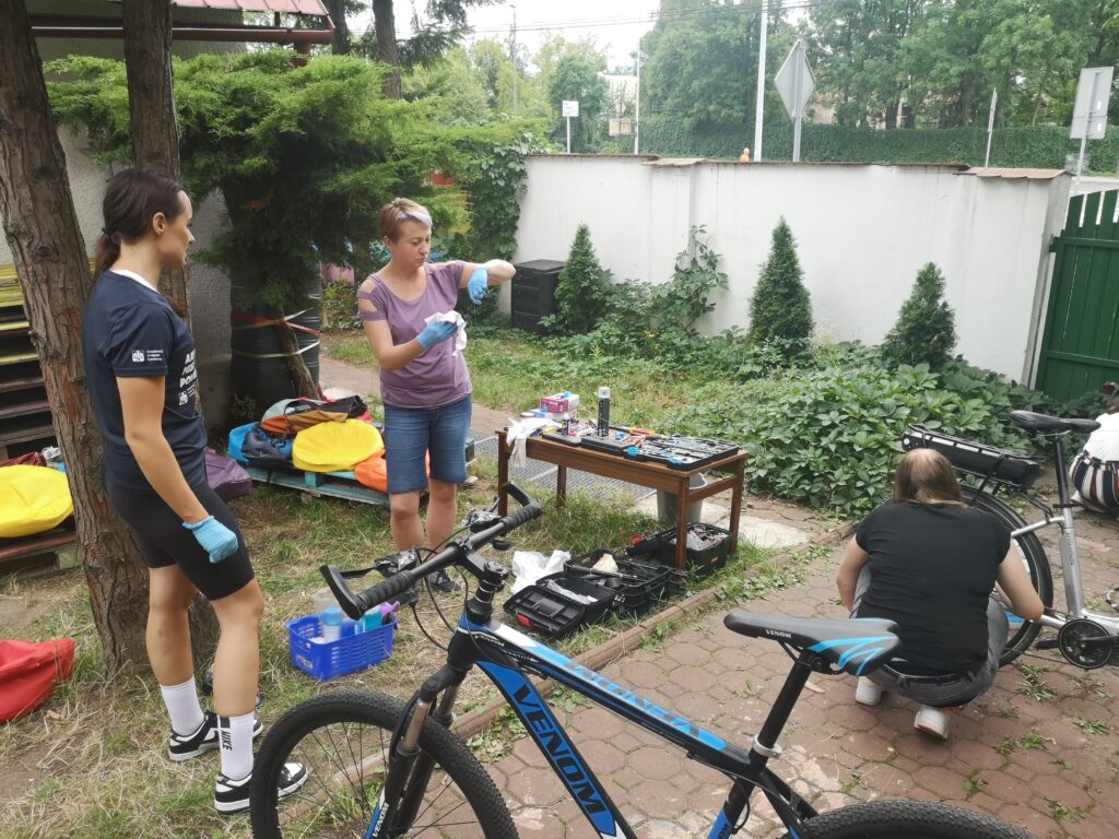 Kobiety podczas czynności serwisowych przy rowerach.